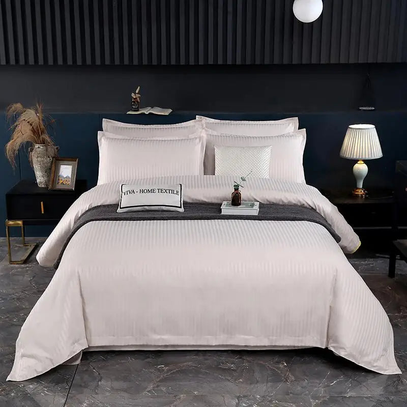 Neatly made bed with off white bedding and pillows in a bedroom setting.