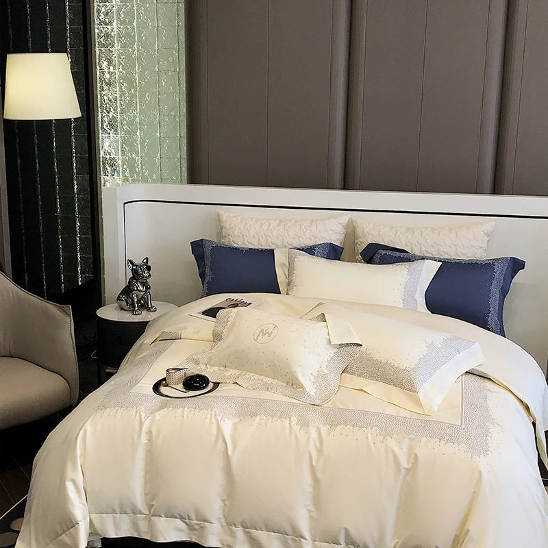 Neatly made bed with white and blue pillows in a bedroom setting.