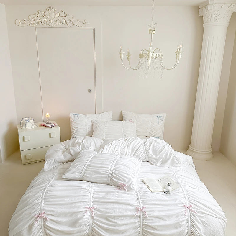 Neatly made bed with white bedding in a bright bedroom.