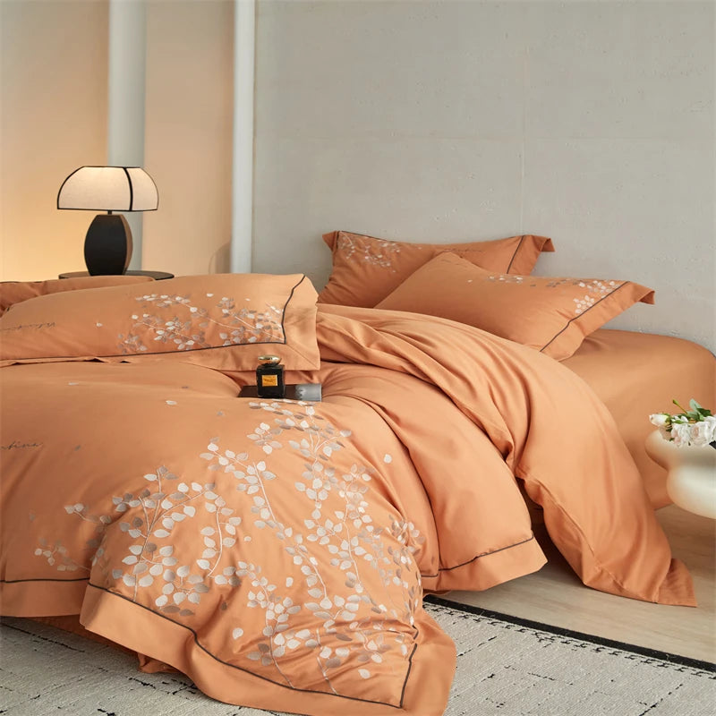 Orange floral bedding set on a bed in a bedroom setting.