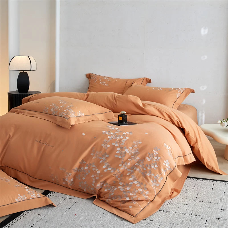 Orange floral patterned bedding set on a bed in a modern bedroom.