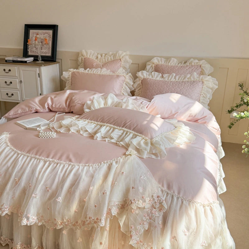 Pink and white ruffled bedding set on a bed in a bedroom.