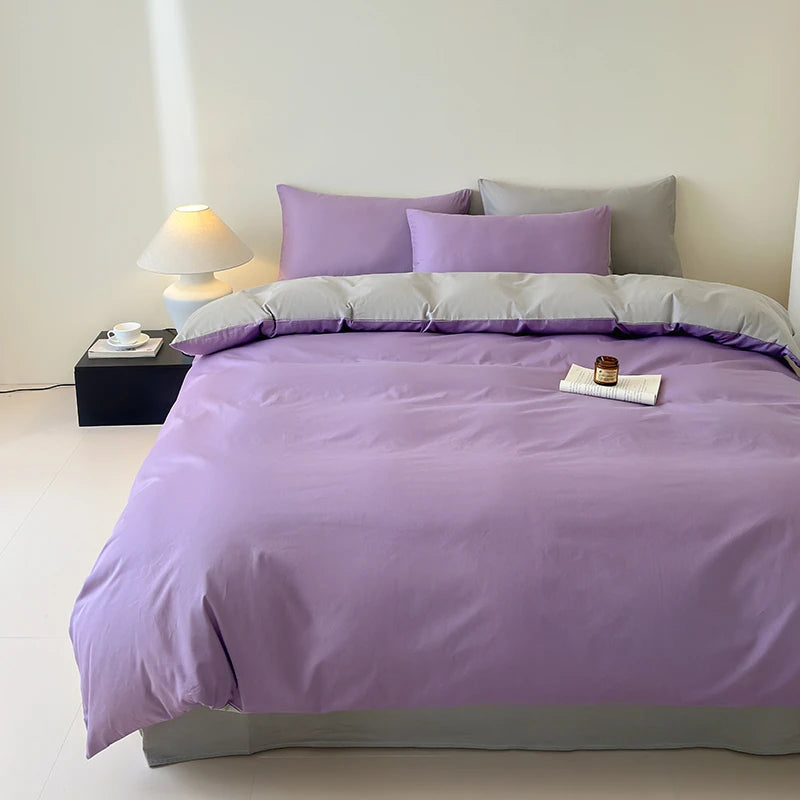 Purple bedding set on a bed in a minimalistic bedroom.