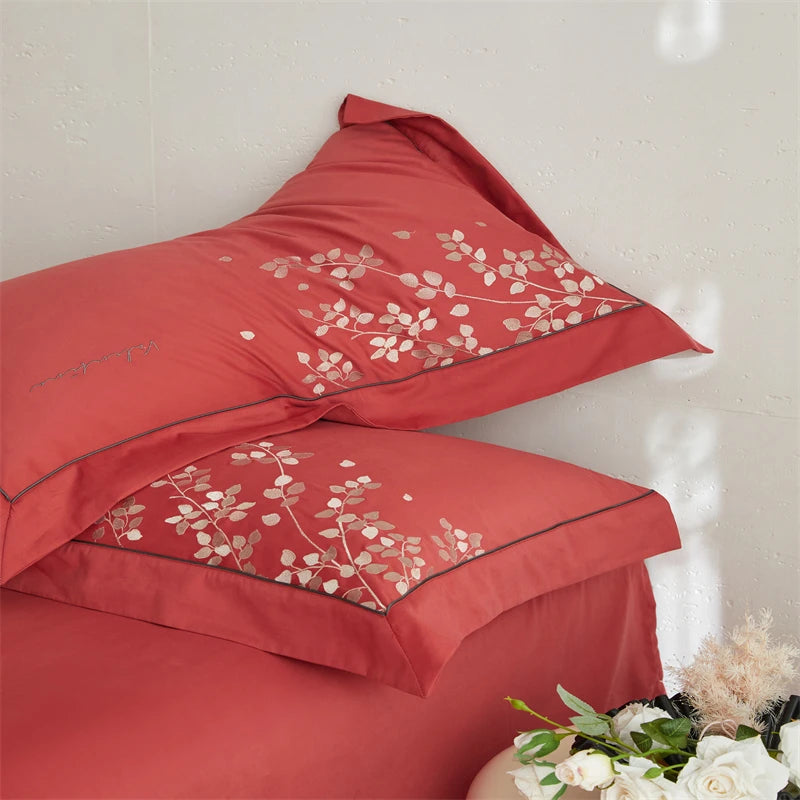 Red bedspread with floral embroidery on a white background