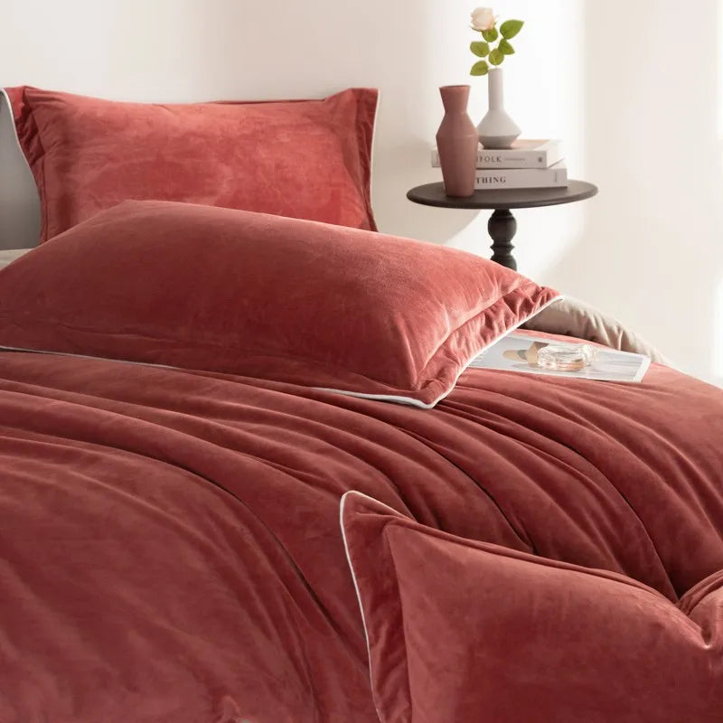 Rust velvet bedding set on a bed with a side table in the background