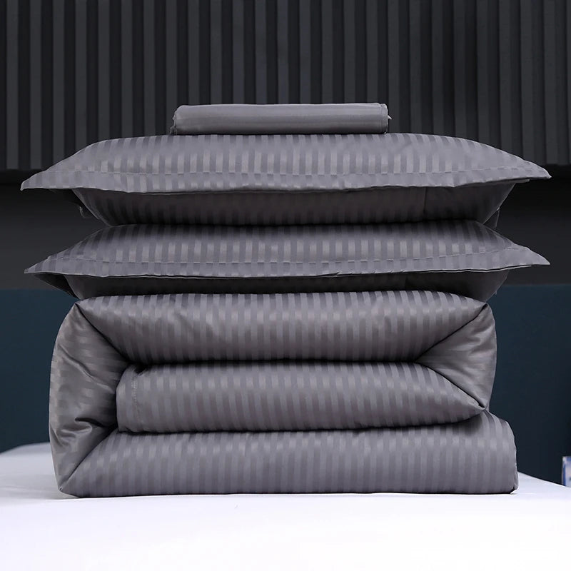 Stack of gray striped bedding on a bed with a dark background