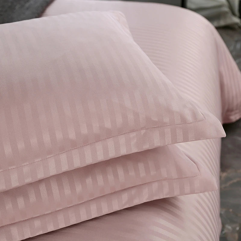 Stack of pink striped pillows on a neutral background