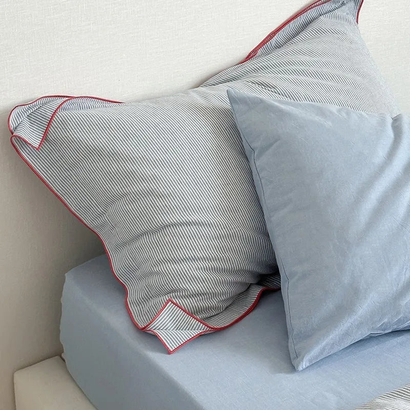 Two pillows on a bed with light blue bedding