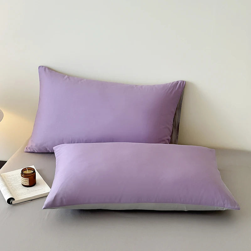 Two purple pillows on a light gray surface with a white background