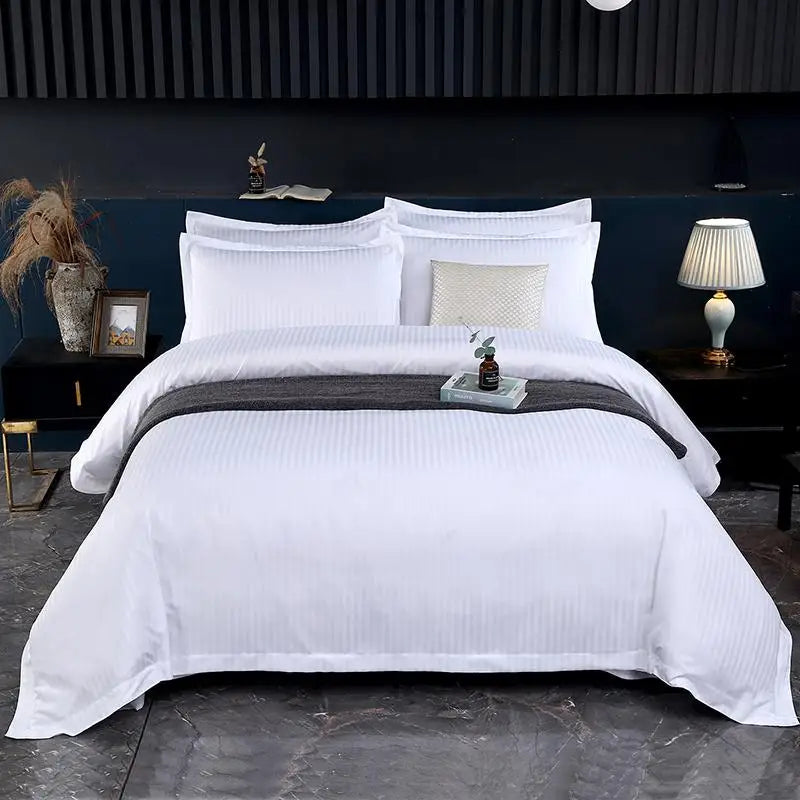 White bedding set on a bed with nightstands and decor in a bedroom setting.