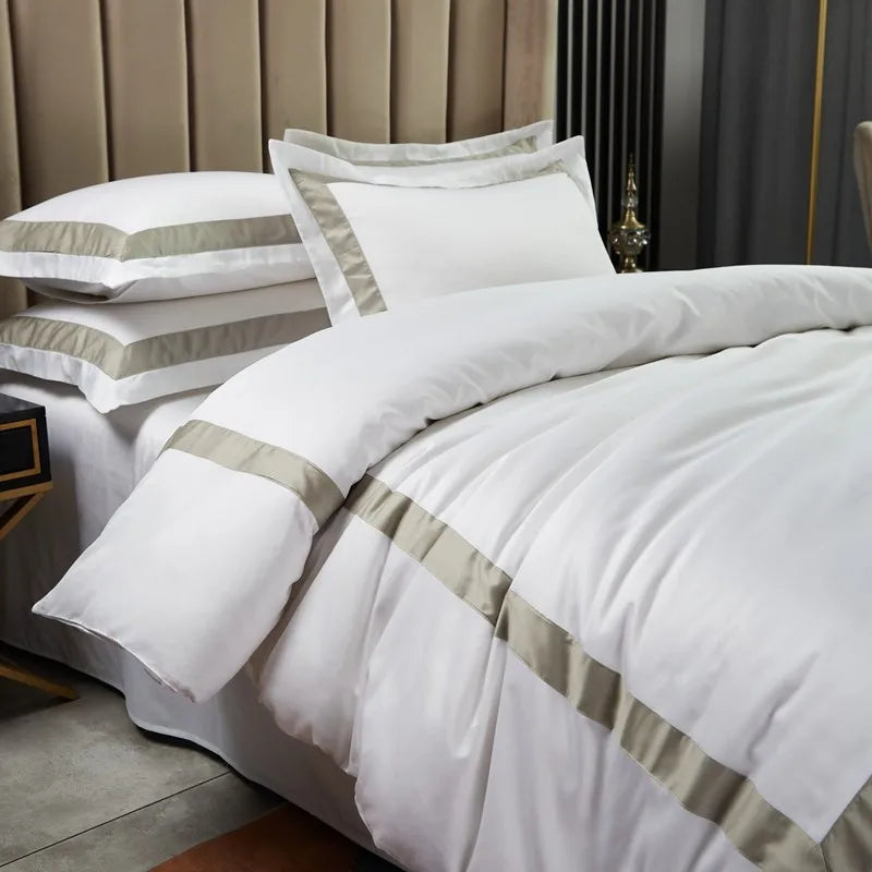 White bedding set with beige stripes on a bed in a bedroom setting.