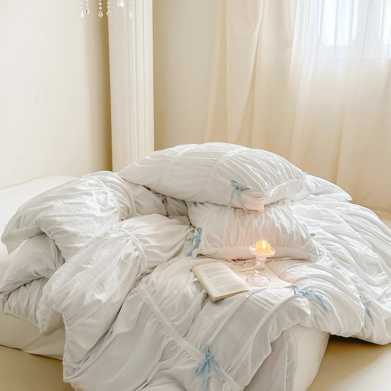 White comforter on a bed pleated bedding set