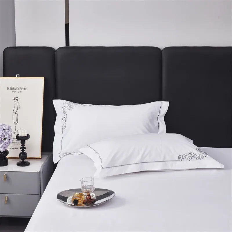 White embroidered pillowcases on a bed