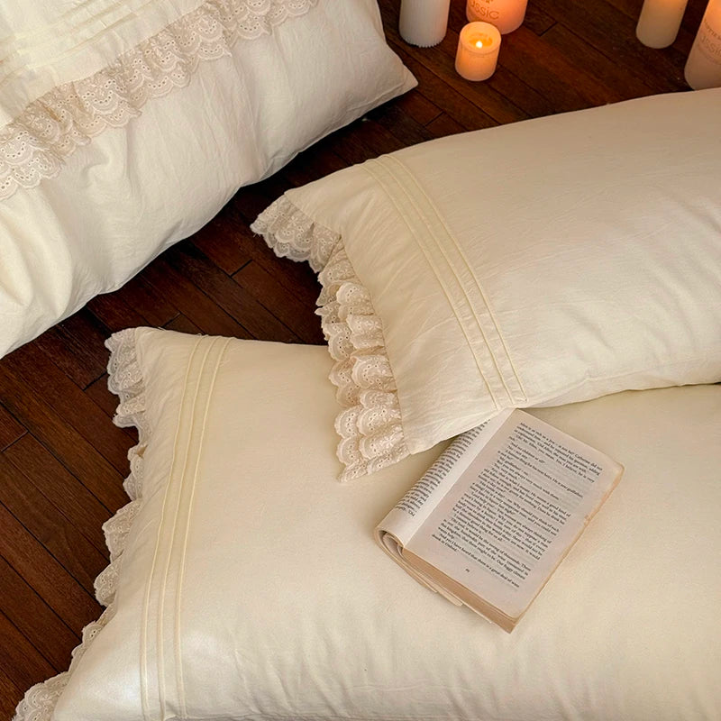 White pillows with lace trim on a wooden floor