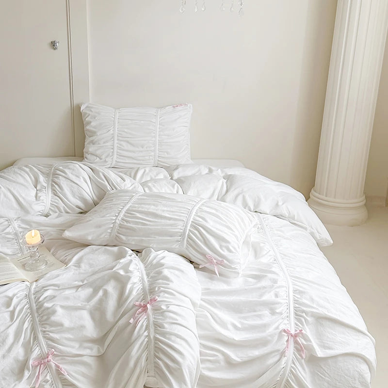 White ruffled bedding set on a bed in a minimalistic room.