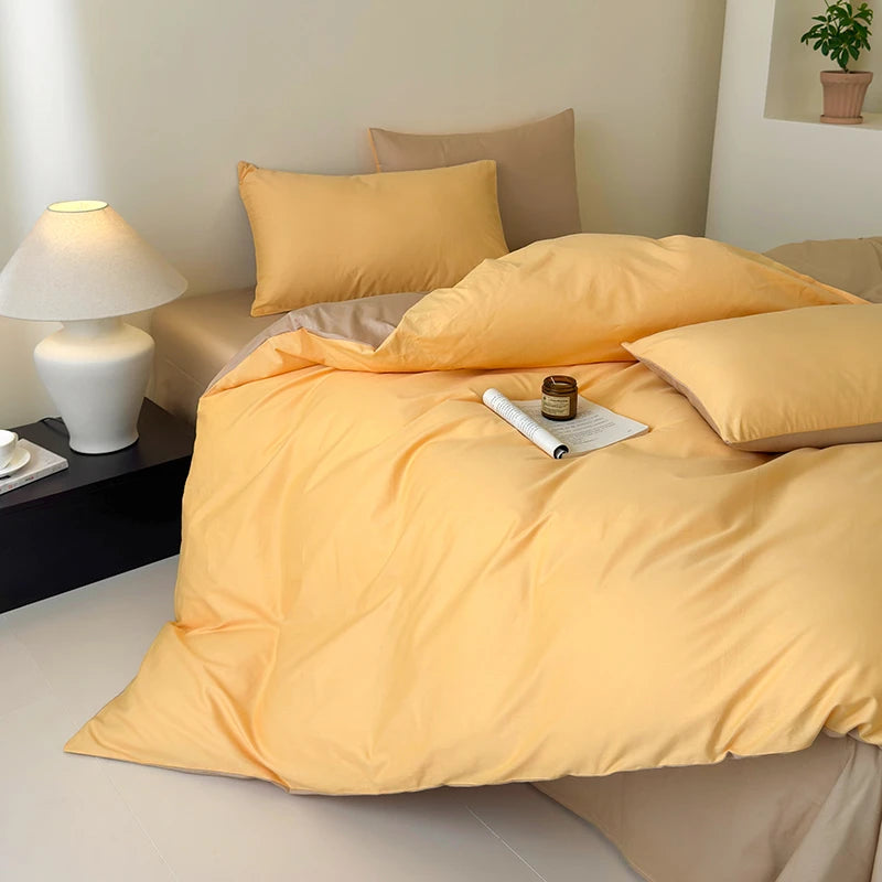 Yellow bedding set on a bed with a lamp and plant in the background