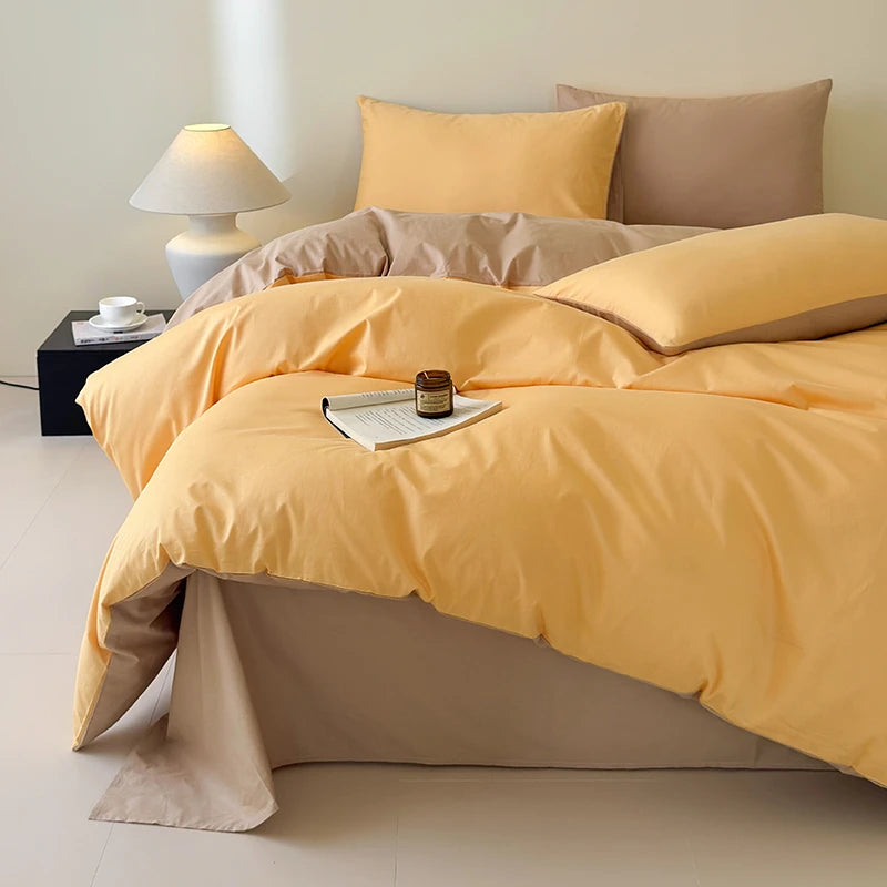 Yellow bedding set on a bed with a side table and lamp in a bedroom setting.